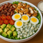 Cobb Salad with Homemade Ranch Dressing featuring chicken, eggs, avocado, bacon, and fresh vegetables in a large bowl.