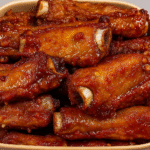 Sticky Honey Garlic Ribs glazed with honey garlic sauce in a ceramic dish