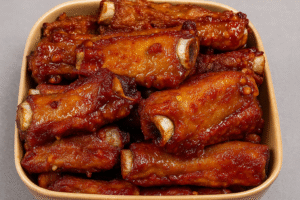 Sticky Honey Garlic Ribs glazed with honey garlic sauce in a ceramic dish