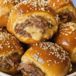 Smoked Brisket & Beer Cheese Pretzel Bombs on a white plate, golden brown and topped with coarse salt.