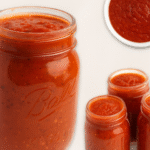 Homemade tomato sauce in glass jars, rich red sauce made with fresh tomatoes, garlic, and basil for pasta and pizza.