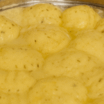 Old-Fashioned Chicken and Dumplings in a pot with fluffy dumplings on top, comforting classic dinner recipe.