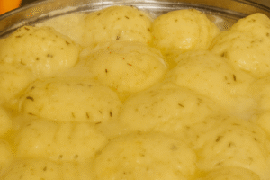 Old-Fashioned Chicken and Dumplings in a pot with fluffy dumplings on top, comforting classic dinner recipe.
